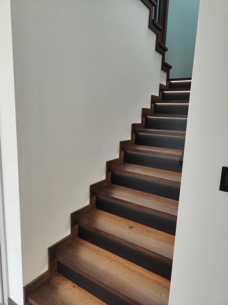 Schody dębowe w nowoczesnym wnętrzu z oświetleniem LED